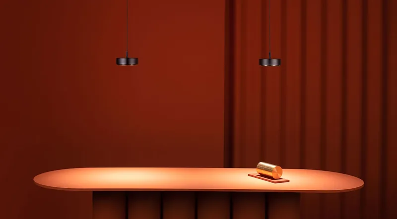 Dwa czarne zwisy nad owalnym stołem na tle ceglastej ściany z zasłoną — Chors