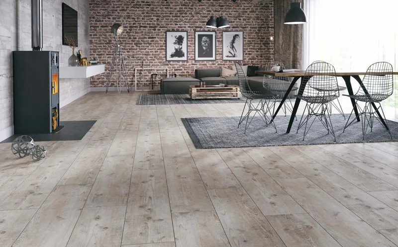Industrialne wnętrze z wolnostojącym piecem i ceglaną ścianą, szaro-bielona sosna (Villa 4V, Bordeaux Pine) — Classen