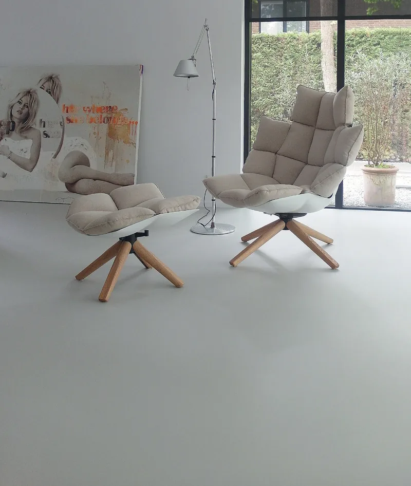 Wypoczynek z dwoma fotelami przy przeszklonej ścianie, jasna bezspoinowa posadzka wylewana Quartzline DECO — Eurostep / Quartzline