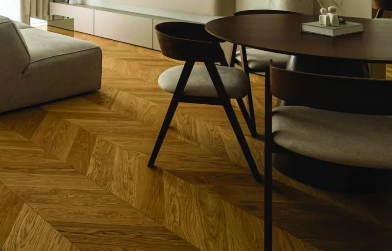 Strefa jadalna z okrągłym stołem i tapicerowanymi krzesłami, dębowa jodełka francuska — Holz Floors