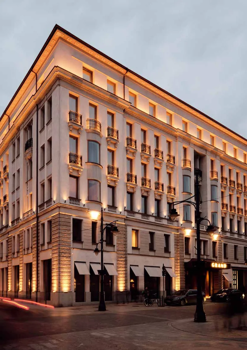 Elewacja kamienicy wielkomiejskiej o zmierzchu — tynk mineralny w odcieniu piaskowym — KEIM