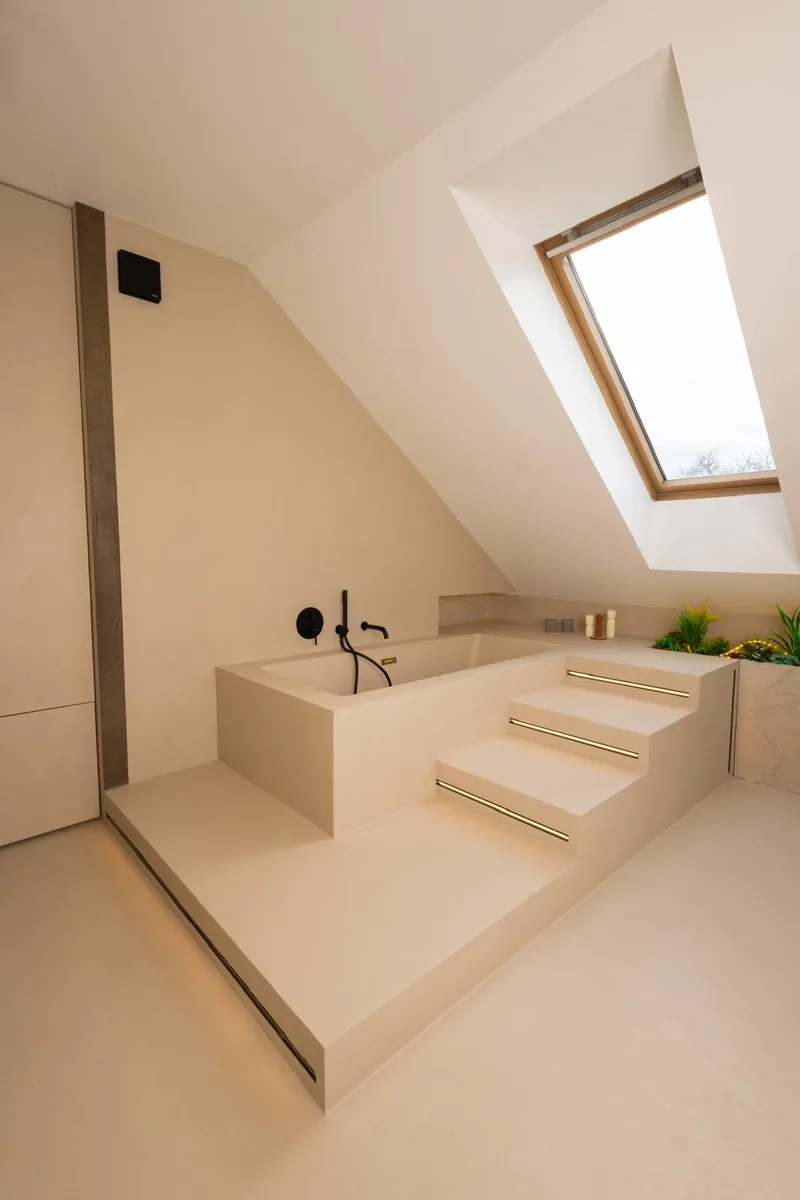 Wanna murowana wykończona mikrocementem pod oknem połaciowym — Basebeton / realizacja Lux-Bud Design