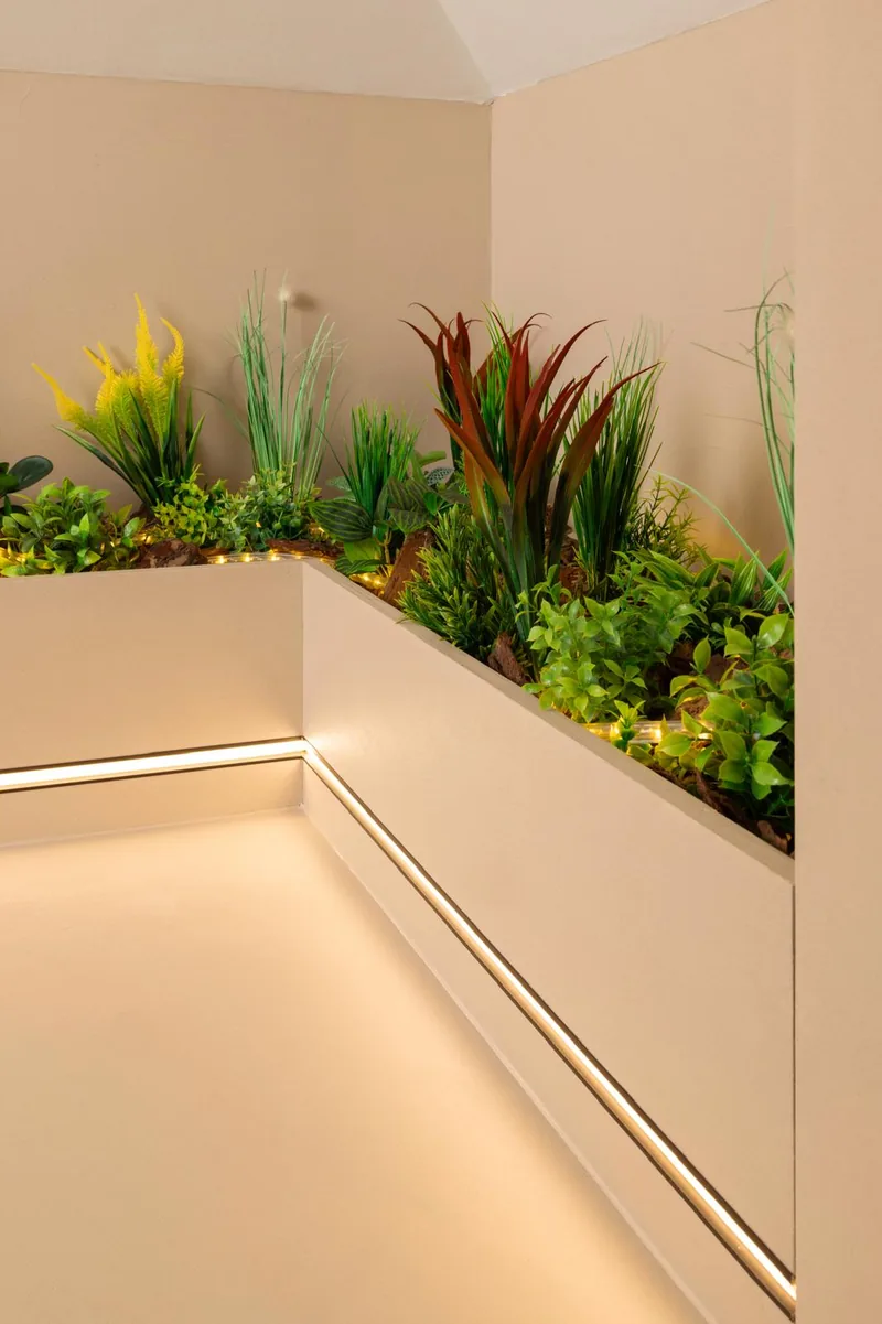 Donice z zielenią i listwa LED wzdłuż mikrocementowej ściany — Basebeton / realizacja Lux-Bud Design