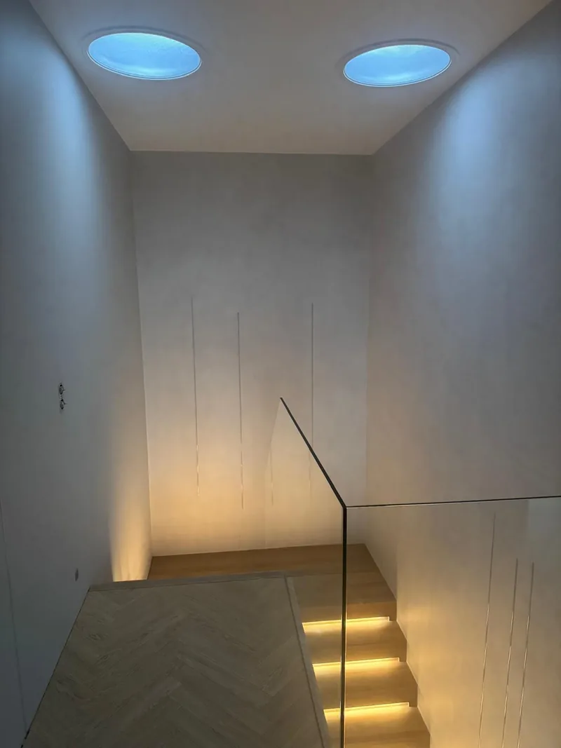 Zejście po schodach z mikrocementu, podświetlone stopnie — Basebeton / realizacja Lux-Bud Design