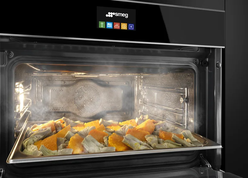 Otwarty piekarnik parowy Smeg z potrawa na blasze, zblizenie na komore i prowadnice — Smeg