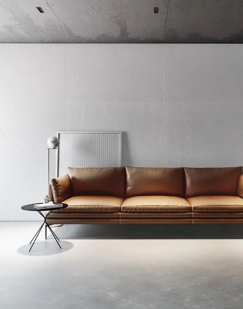 Tasma LED w cokole sciany za skorzana sofa w salonie z betonowa posadzka