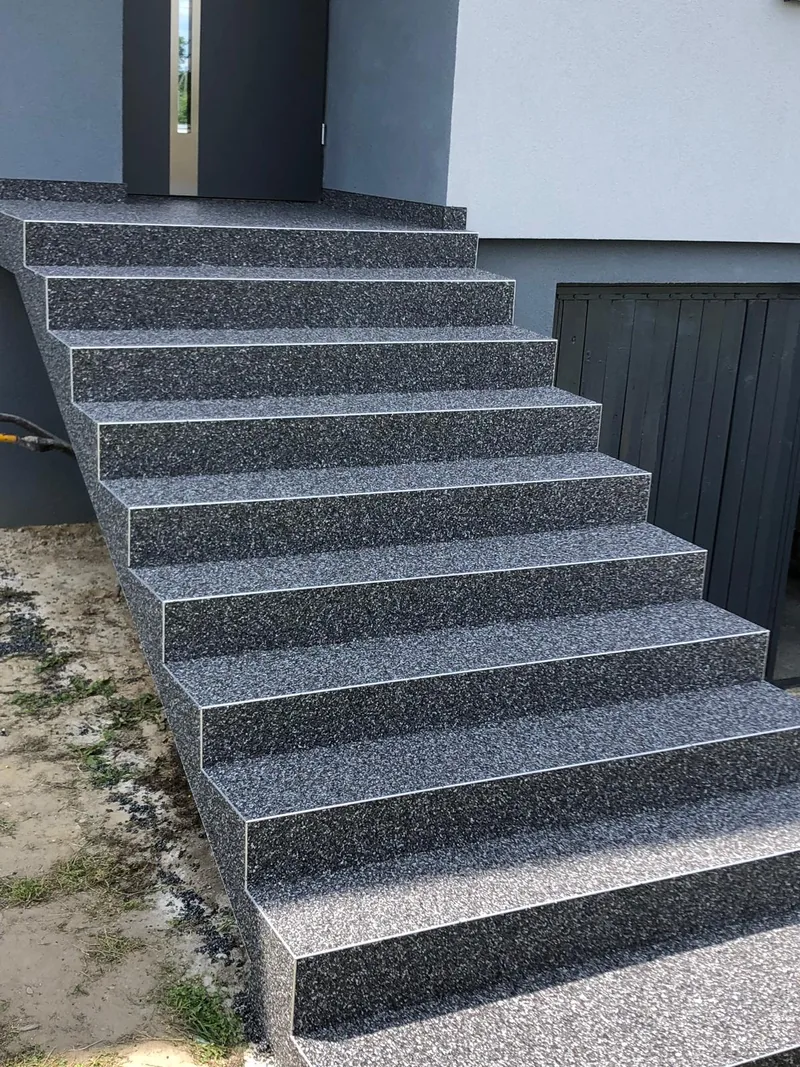 Ciemne schody zewnętrzne z kamiennego dywanu — realizacja LuxBud Design, Częstochowa
