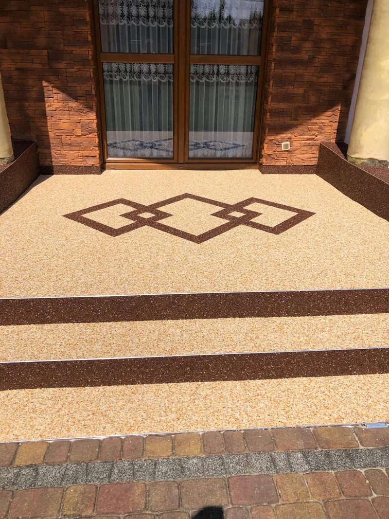 Wejście z ozdobnym wzorem w kamiennym dywanie — realizacja LuxBud Design, Częstochowa